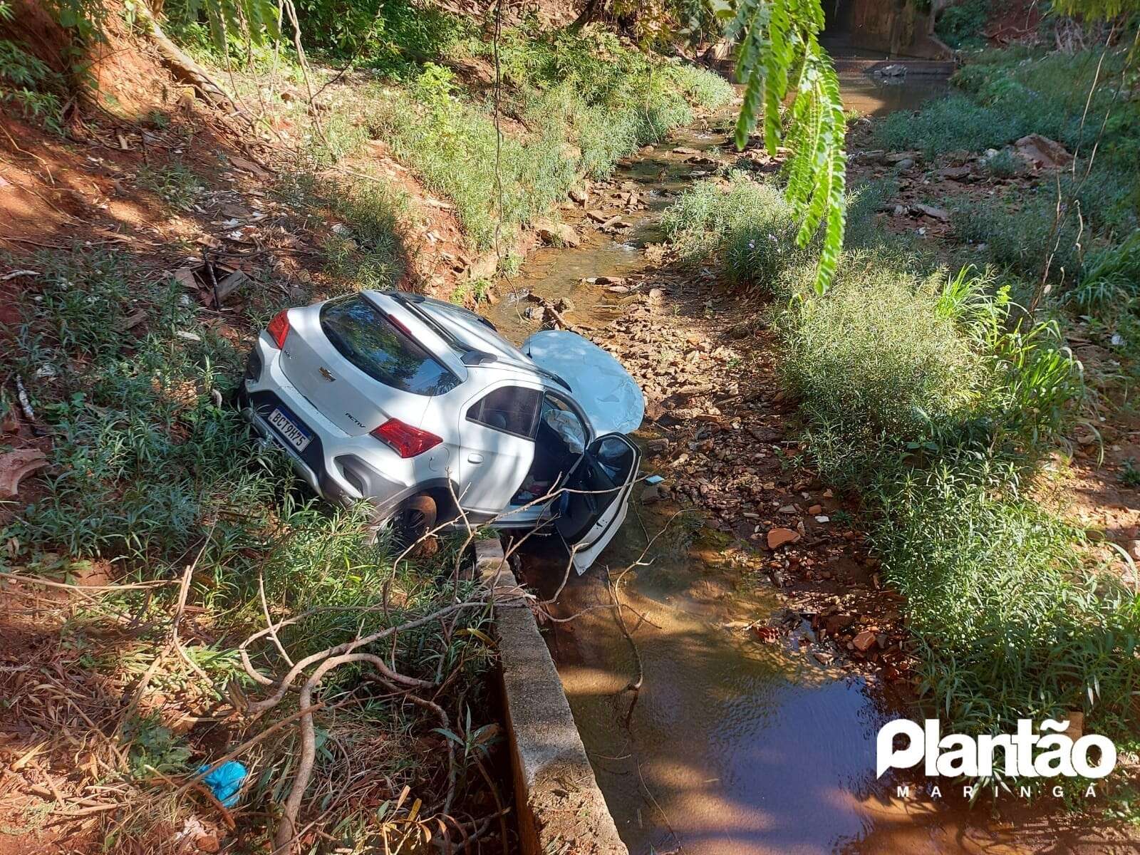 Após colisão carro despenca de aproximadamente 8 metros e cai dentro de